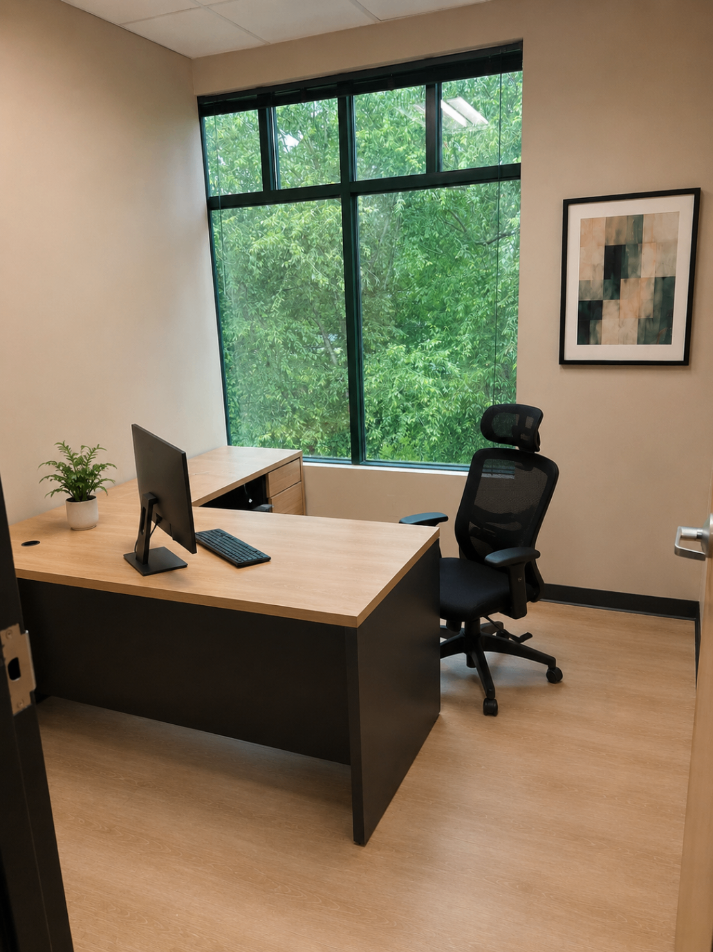 Private office with corner desk, framed art, and a large window